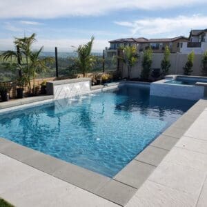 A clean outdoor swimming pool with clear water and scenic surroundings.